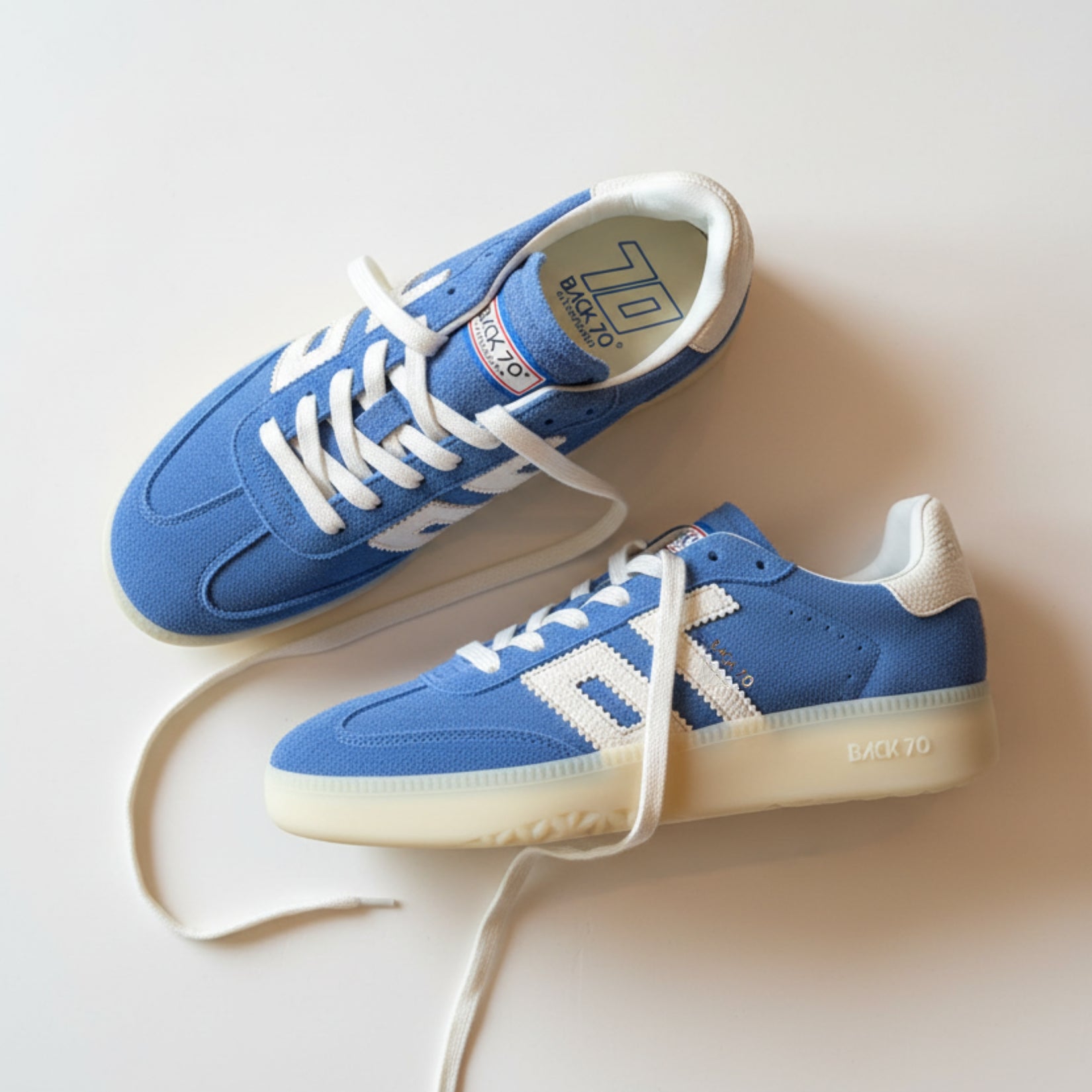 Blue sneakers with white laces on a light background