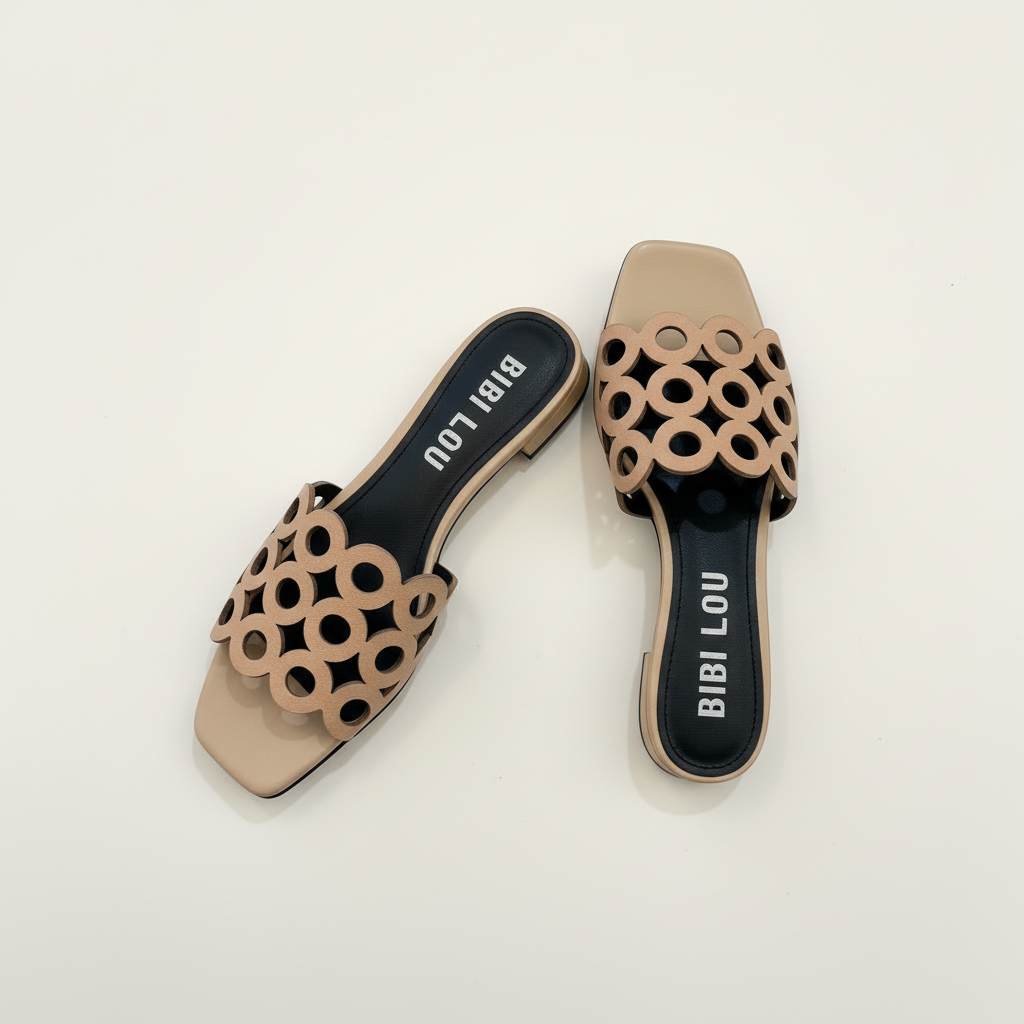 Pair of beige sandals with circular cut-out design on a white background, branded 'BIBI LOU'.