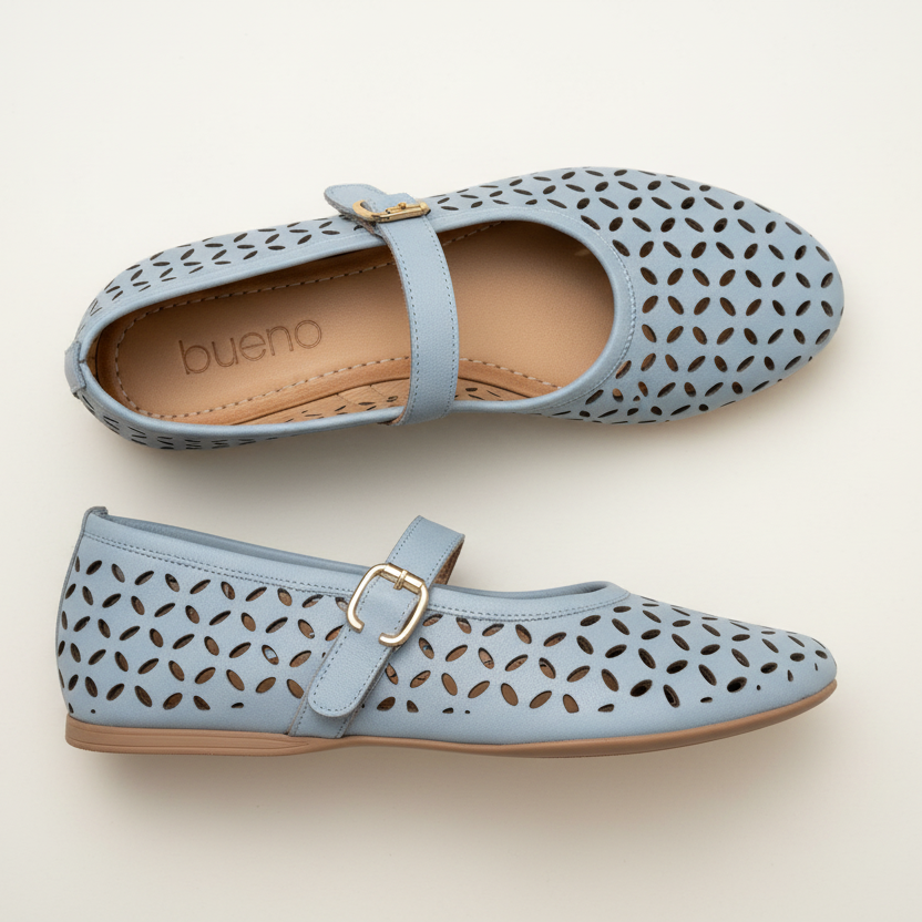 Pair of light blue perforated shoes with a strap on a beige background