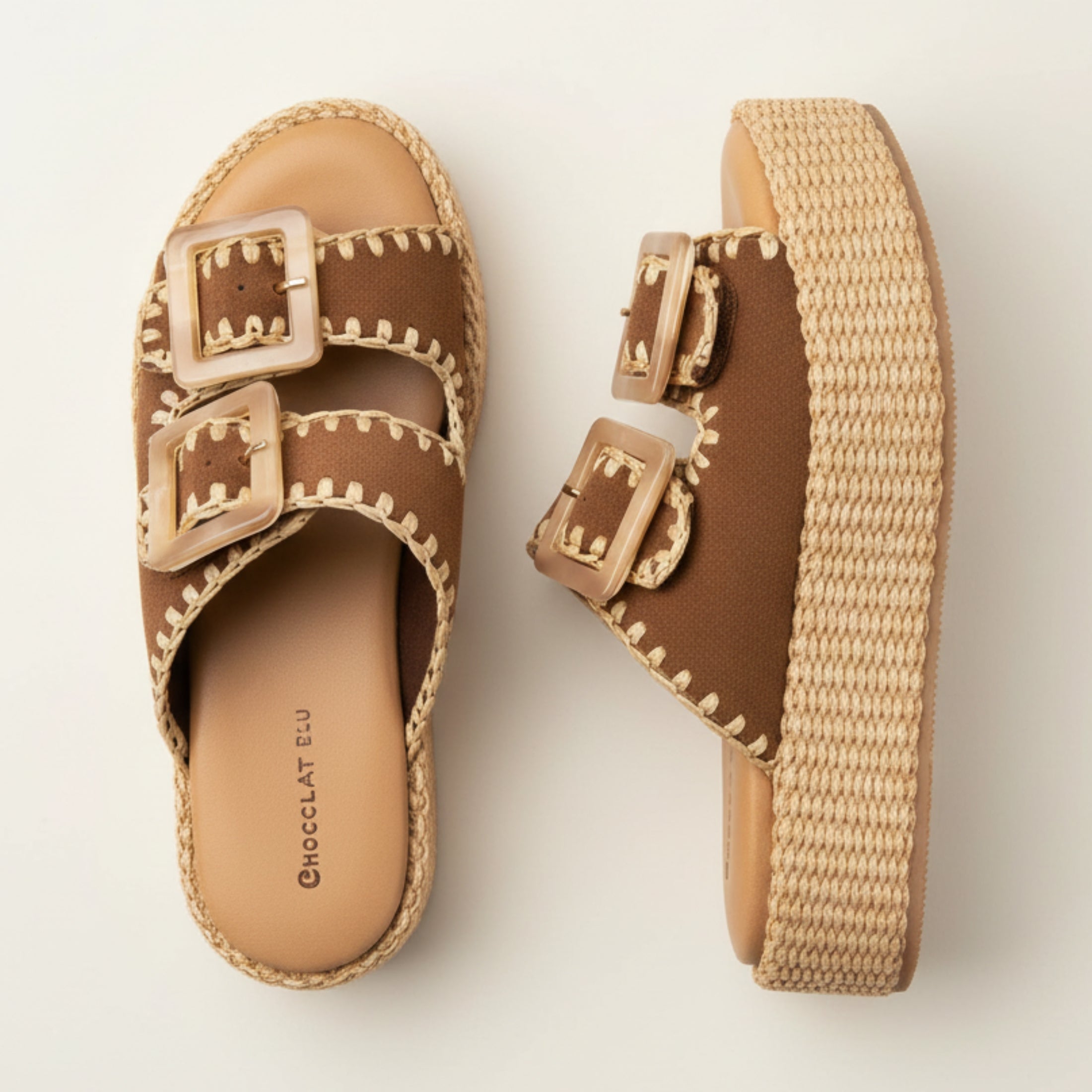 Brown sandals with raffia straps and buckles on a light background
