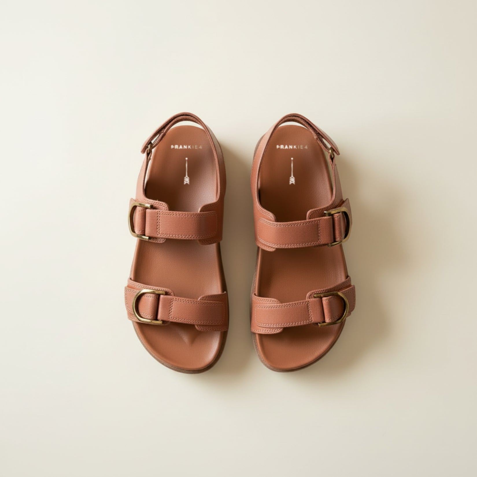 Pair of brown sandals on a beige background