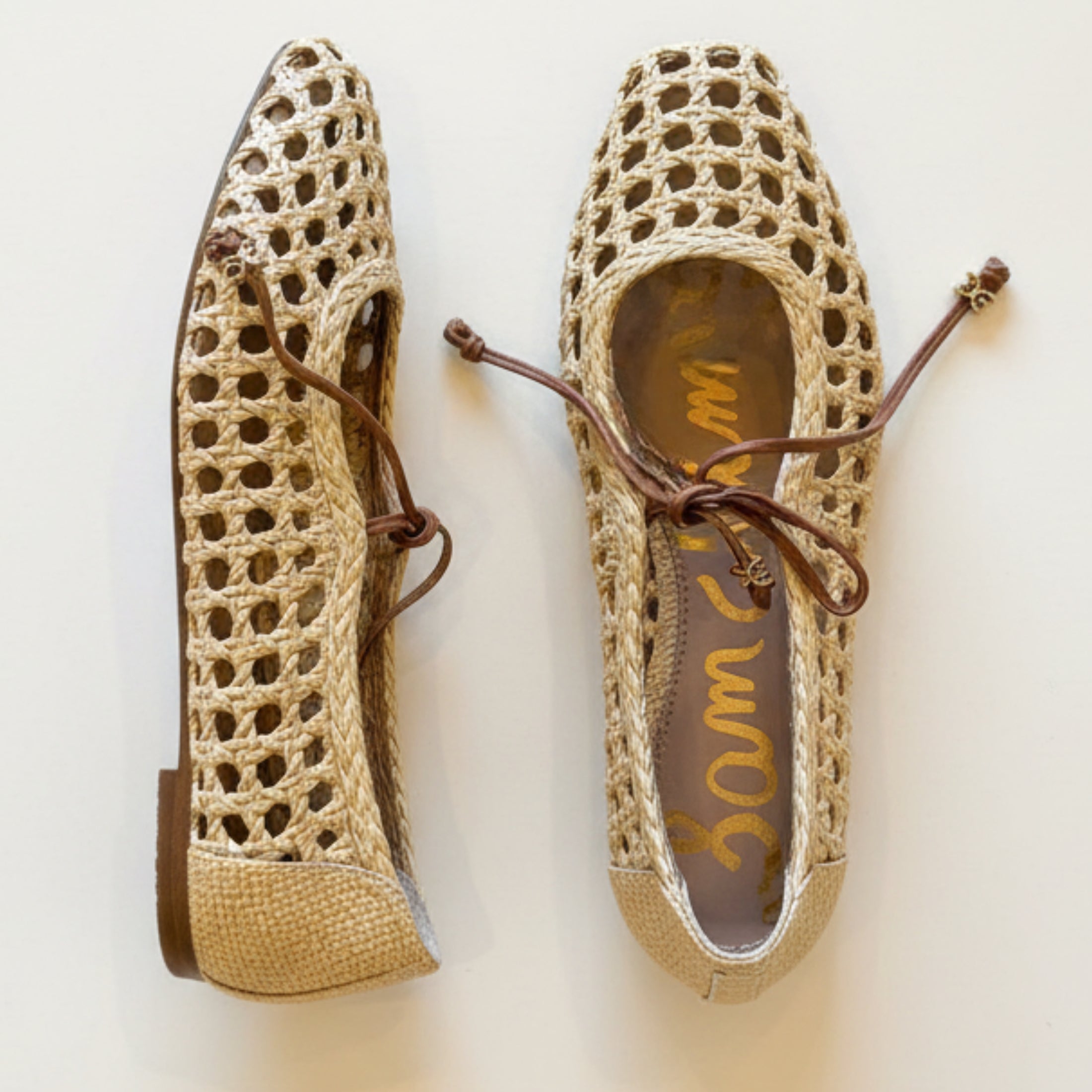 Pair of woven shoes with brown laces on a light background