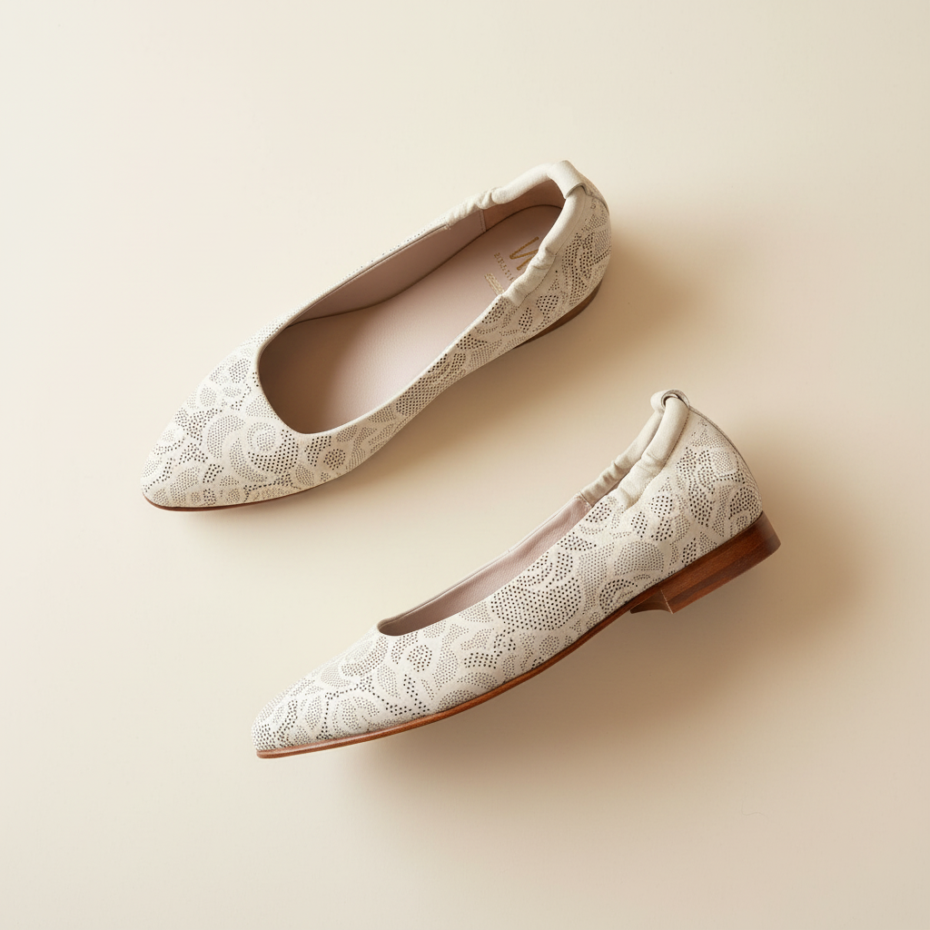 Pair of white lace shoes on a beige background
