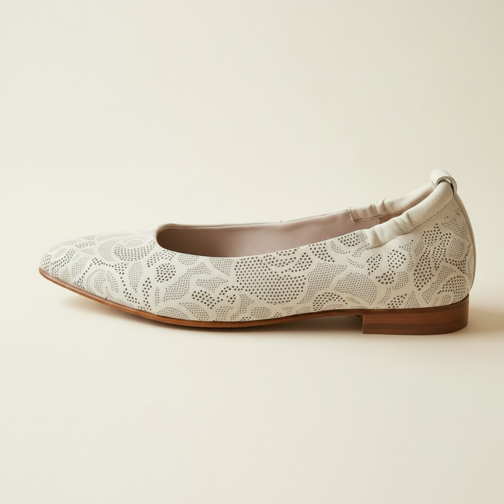 White lace flat shoe on a beige background