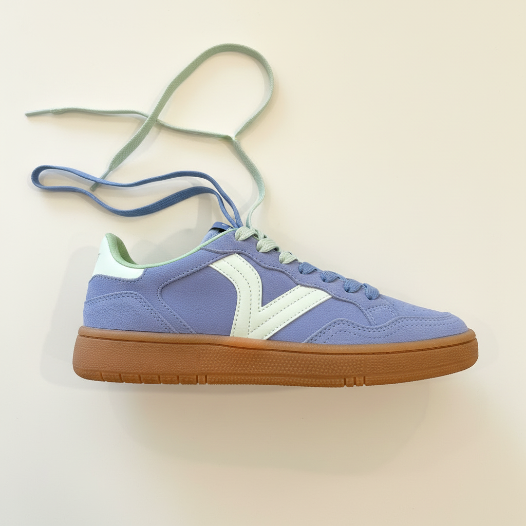 Blue sneaker with brown sole on a beige background