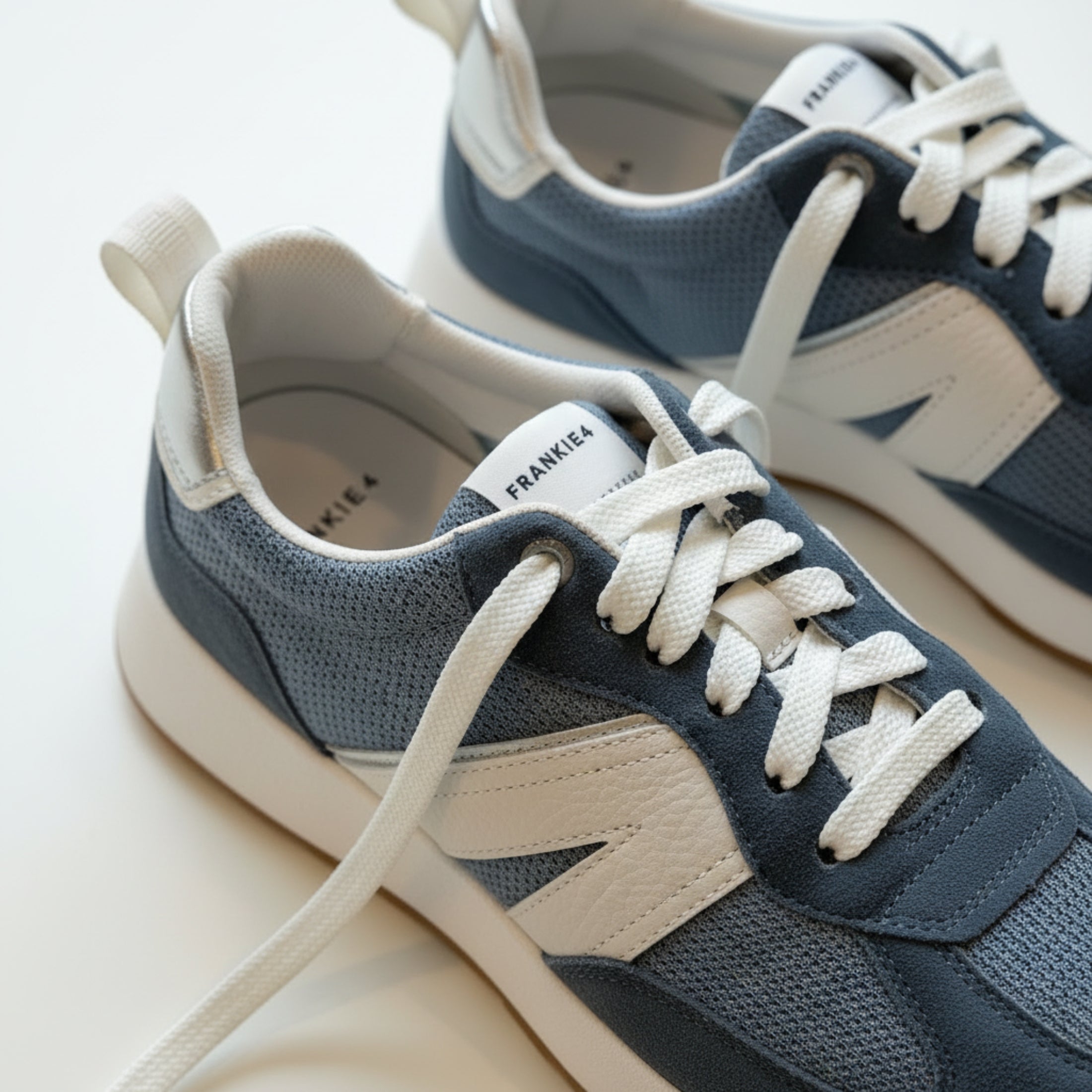 Pair of blue and white sneakers on a light background