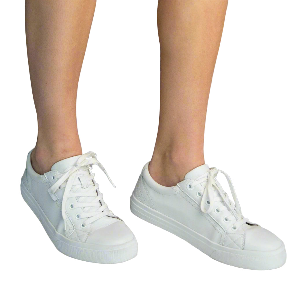 White sneakers worn on a white background