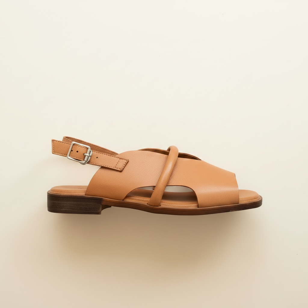 Tan sandal with a single strap on a beige background