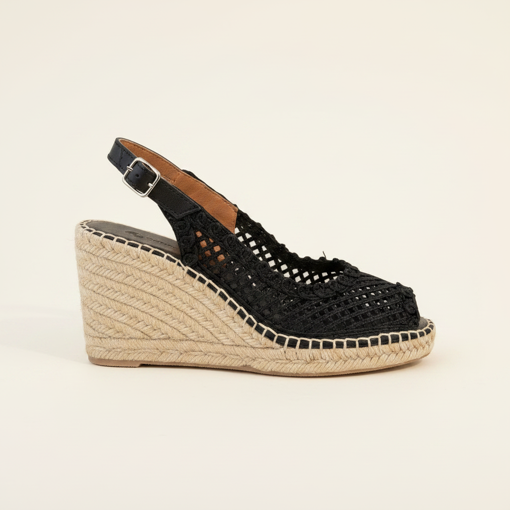 Black wedge sandal with woven sole on a beige background