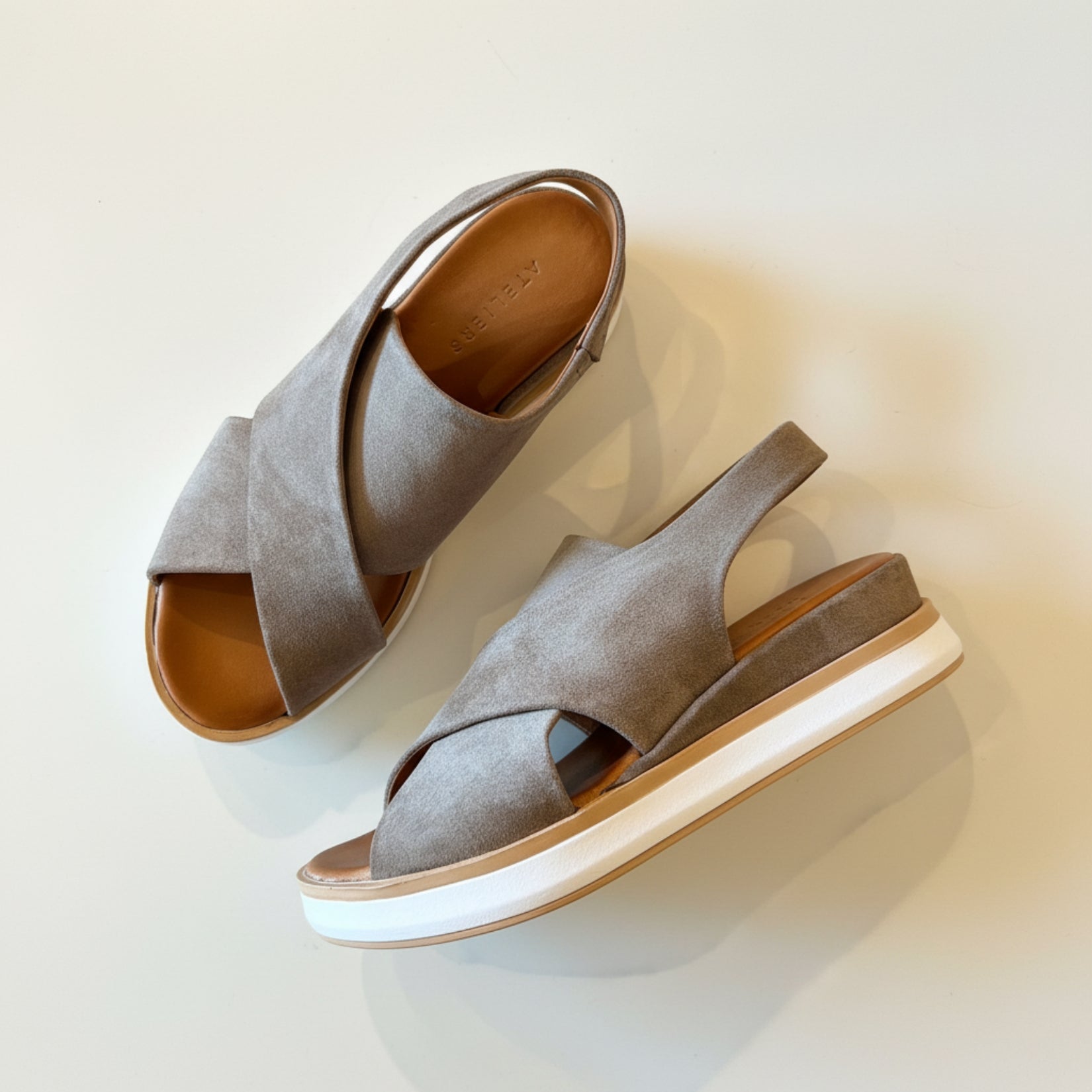 Pair of gray sandals with white soles on a light background