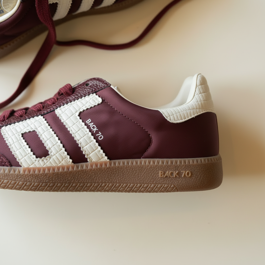 Maroon and white sneaker with 'Back 70' text on a beige background