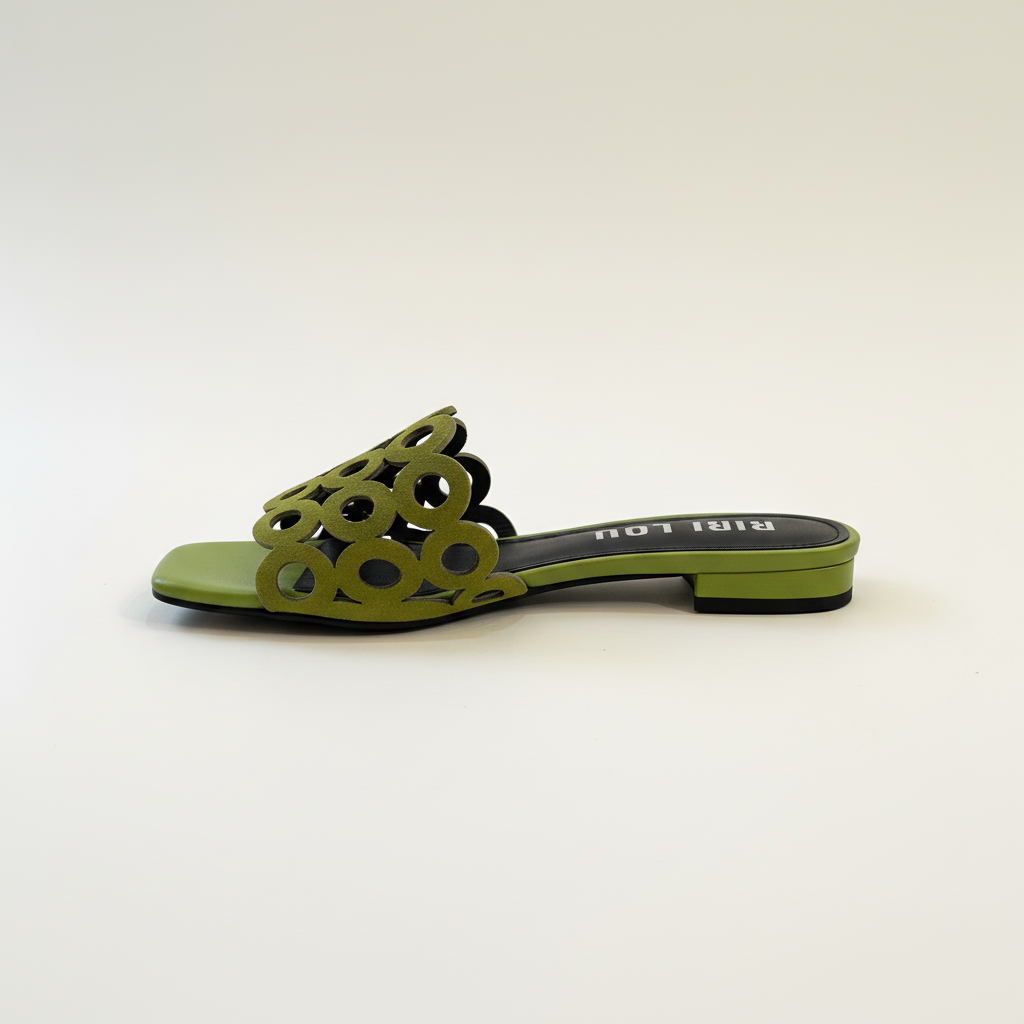 Green sandal with cut-out design on a white background