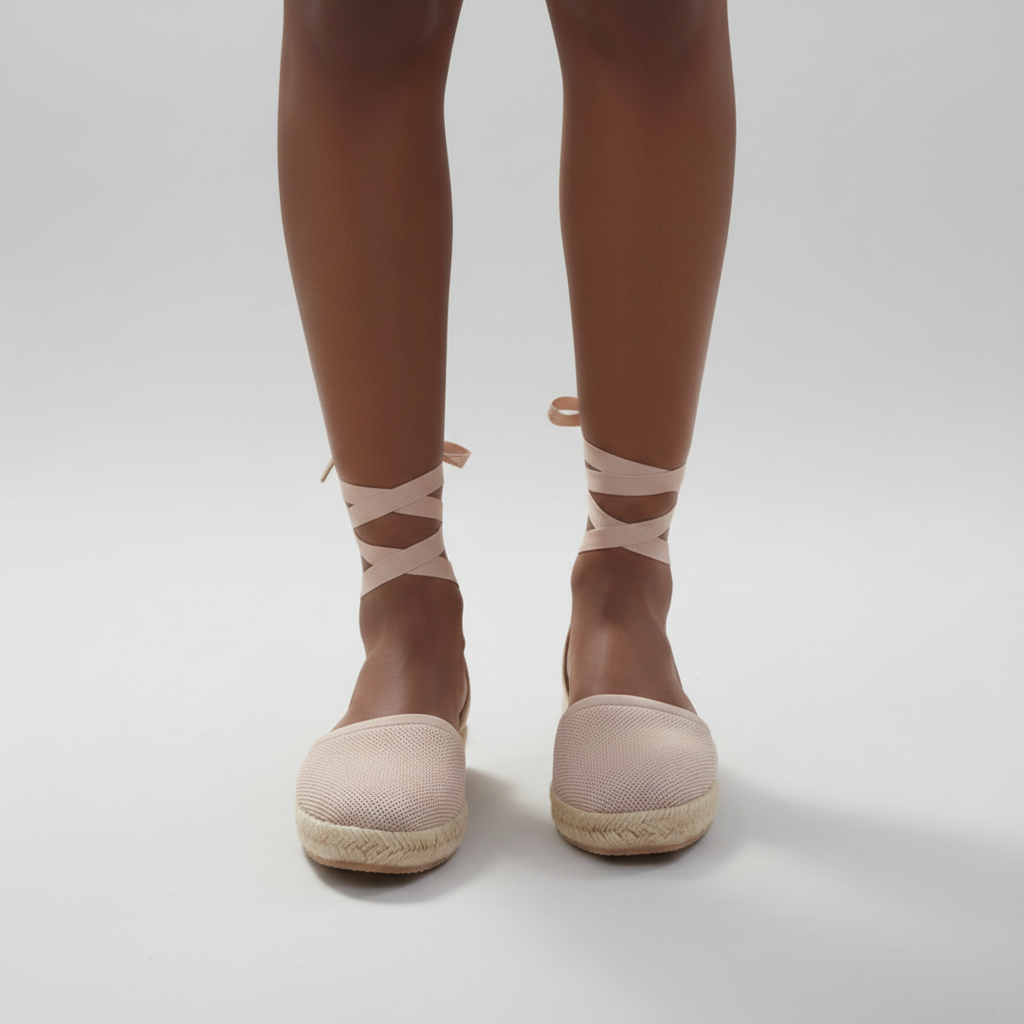 Person wearing beige espadrilles and socks with a white background
