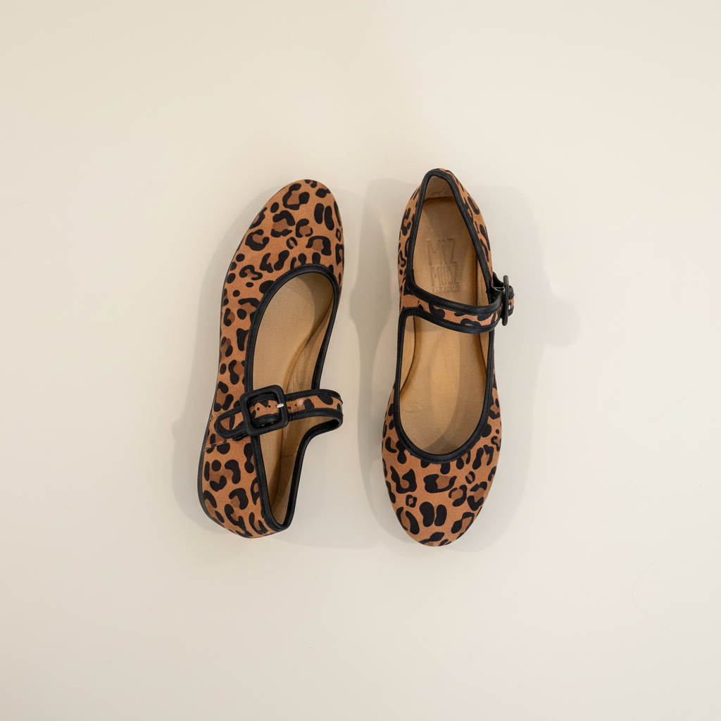 Pair of leopard print shoes with black straps on a beige background