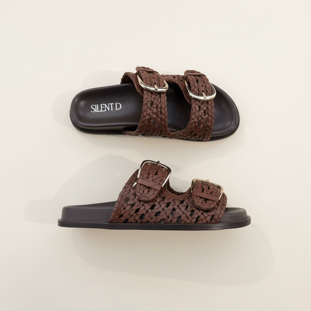 Brown sandals with metallic buckles on a light beige background