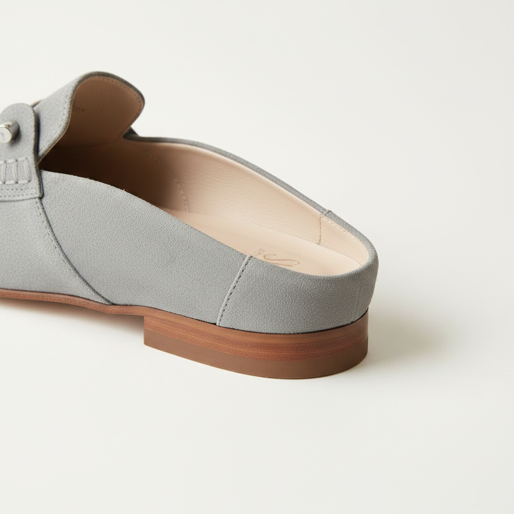 Gray loafer shoe with brown sole on a white background