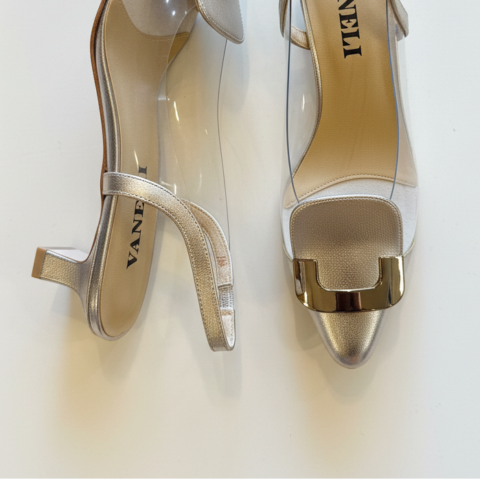 Pair of gold high-heeled shoes with 'Vaneli' branding on a light background