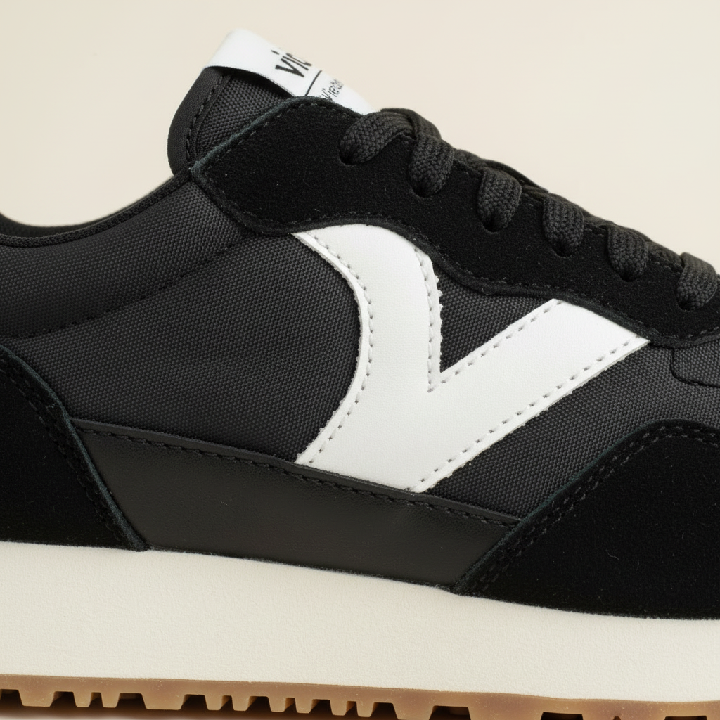 Black and white sneaker with a brand logo on a beige background
